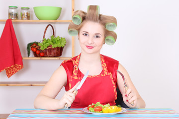 young housewife eating in the kitchen