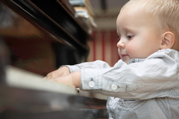 little boy playing piano indoor