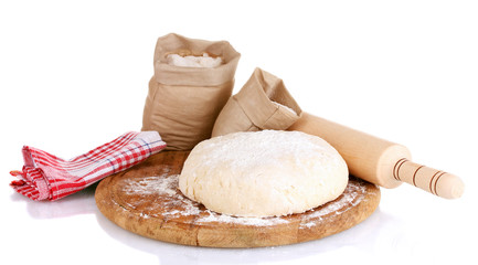 Dough and bags with flour on wooden board isolated on white