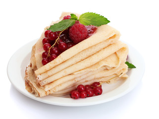 Delicious pancakes with berries and jam on plate on wooden