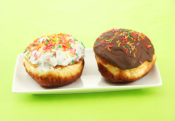 Tasty donuts on color plate on color background