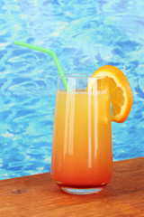 Glass of multicolor cocktail on blue background