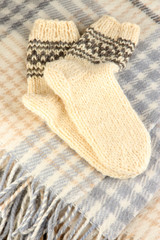 Warm knitted socks on plaid close-up