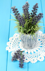 Decorative lavender in vase on blue wooden table close-up