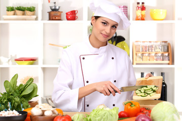 Young woman chef cooking in kitchen