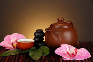 Chinese tea ceremony on bamboo table on brown background