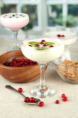 Glass of yoghurt dessert with fruits and berries,