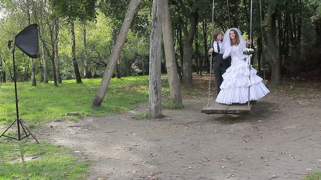 marrying couple on a swing. Photographing process. wedding