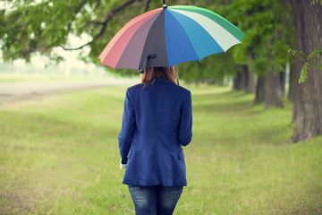 Young fashion girl with umbrella at spring outdoor.