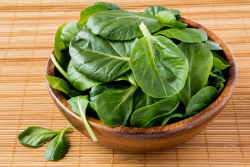 Fresh spinach leaves in wooden bowl