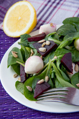 Fresh salad with roasted beets, spinach, mozzarella and seeds