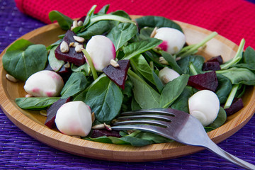 Fresh salad with roasted beets, spinach, mozzarella and seeds