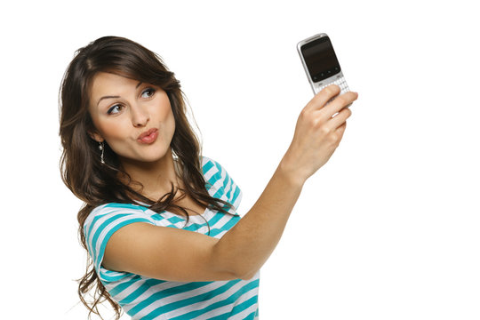 Woman giving kiss while taking pictures through cellphone