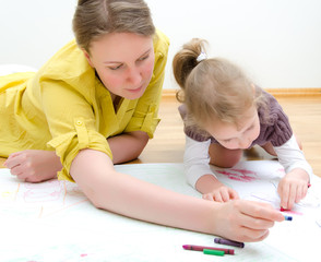 Young woman and little girl drawing together