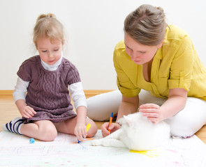 Young woman and little girl drawing together