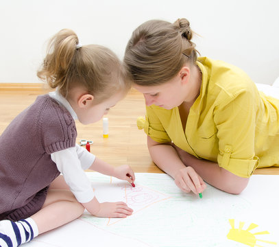 Young woman and little girl drawing together