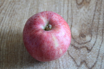 A single red apple displayed on a table