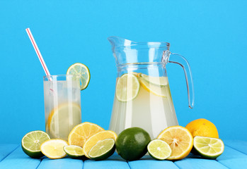 Citrus lemonade in pitcher and glass of citrus around