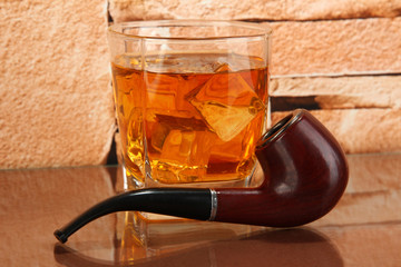 Glass of whiskey and snorkel on brick wall background