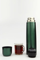 Cup of tea and vacuum flask on the white background