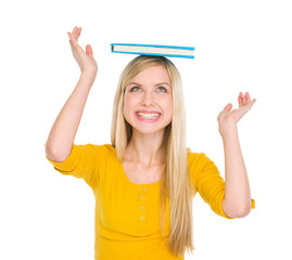 Happy student girl balancing book on head