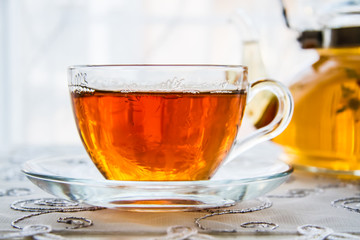 Cup of Tea and a Teapot on White Woodeen Background