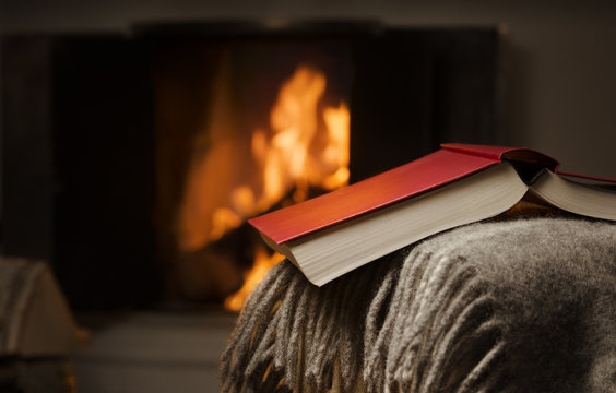 Peaceful and warm image of a open book by fireplace.