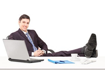 Young businessperson sitting in the office with his legs up