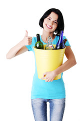 Woman carrying a bin with recyclable glass bottles.