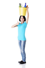 Woman carrying a bin with recyclable glass bottles.