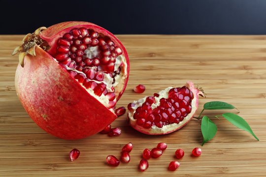 juicy pomegranate open on wood board
