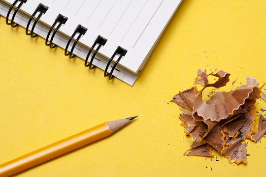 Notebook with pencil on yellow background - Powered by Adobe