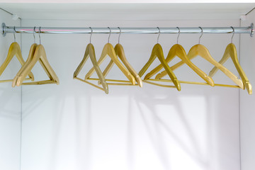 Yellow wooden hangers in a closet