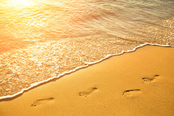 Footsteps on the beach by the sea in summer