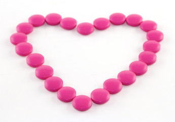 Obraz premium Pink tablets on a white paper