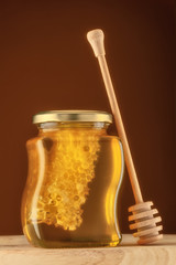 Glass of honey with honeycomb