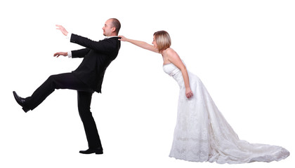  groom tries to run away from the wedding. bride grabs him. isolated on white
