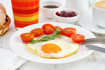 fried egg with tomato and glass of orange juice