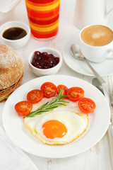 fried egg on the plate with bread, juice and coffee