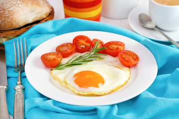 egg with tomato on the plate with bread and juice