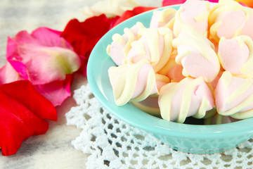 Fototapeta premium Marshmallows on color plate on light background