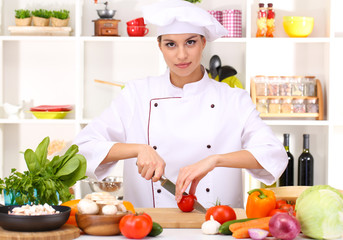 Young woman chef cooking in kitchen