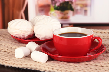 cup of coffee with scarf on table in room