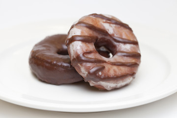 homemade chocolate donuts on plate and white background