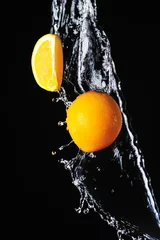 Foto op Canvas Sinaasappel met scheutje water op een zwarte achtergrond © andriikoval