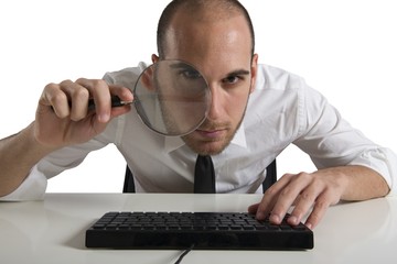 Businessman looks on the computer with a  lens