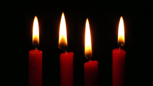 Vier brennende, rote Kerzen