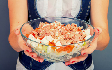 Girl holding tuna salad in salad bowl