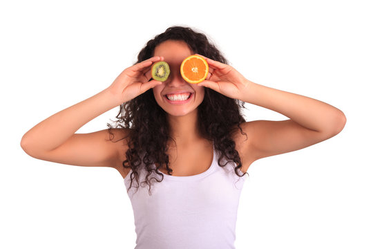 young woman holding orange and kiwi. Isolated over white