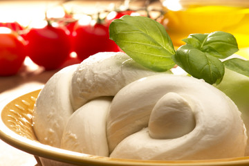 mozzarella cheese with olive oil and tomatoes on wooden table